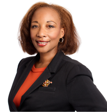 Monique Darrisaw-Akil headshot wearing a navy blazer and red shirt.